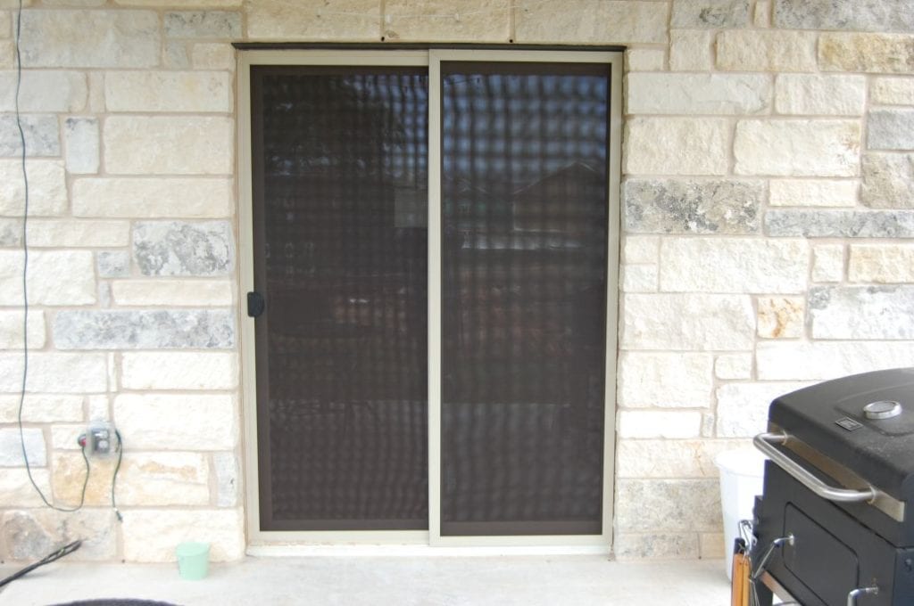 This is a picture taken of a Buda Texas house wearing our solar window screens.