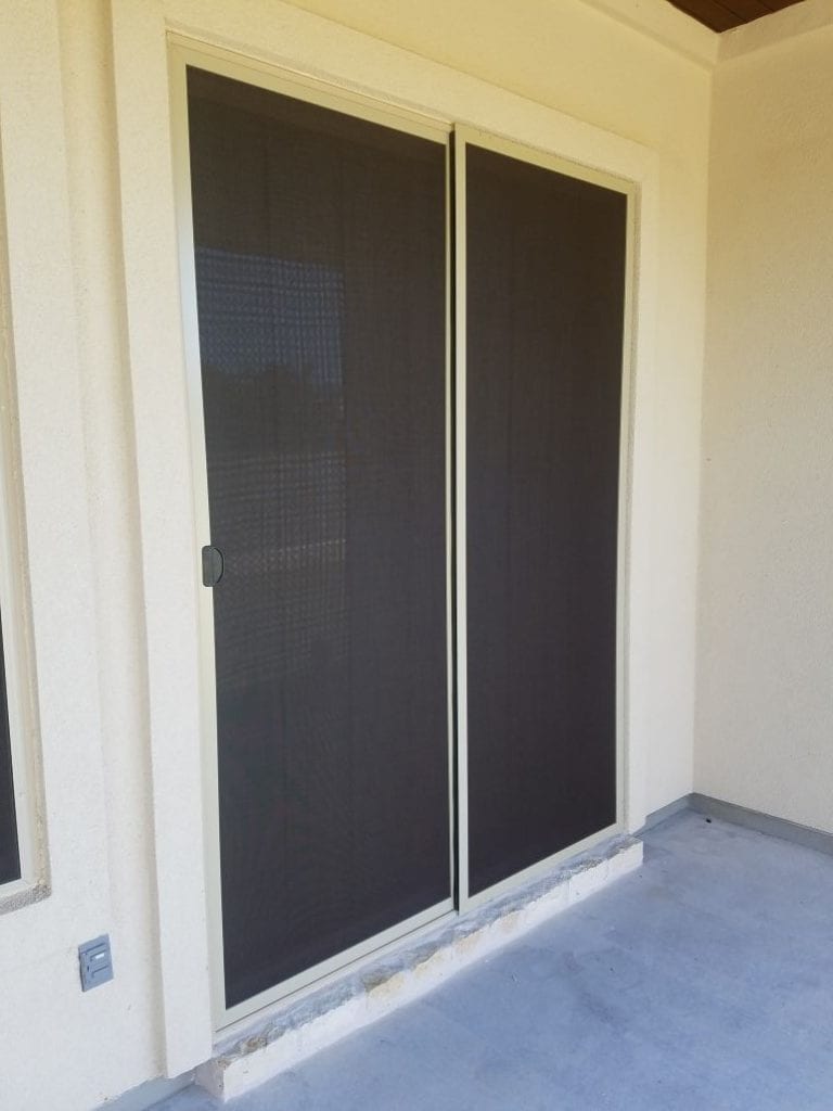 Tan framed 90% chocolate brown solar screens for sliding patio doors. This patio also had outdoor shades installed by us that roll up and down.