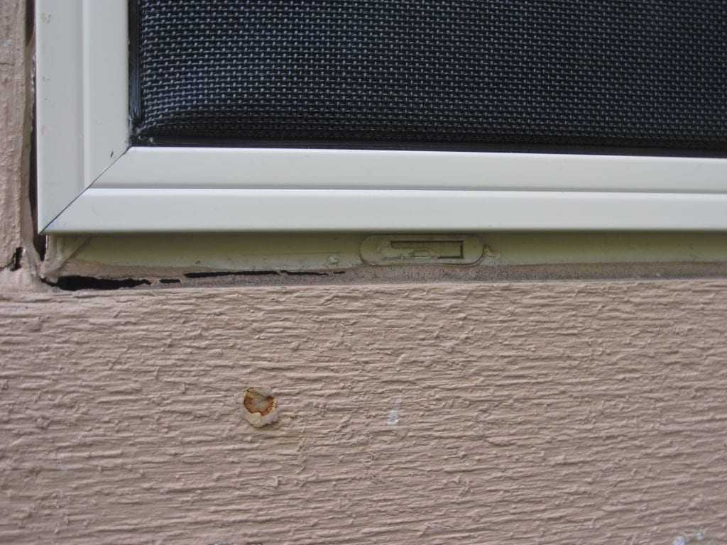 This installed screen avoided the weep holes of this window.